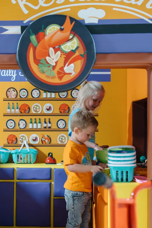 Kids playing in the Funrise pretend kitchen